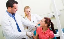 Dentist shakes female patient's hand after a successful operation.